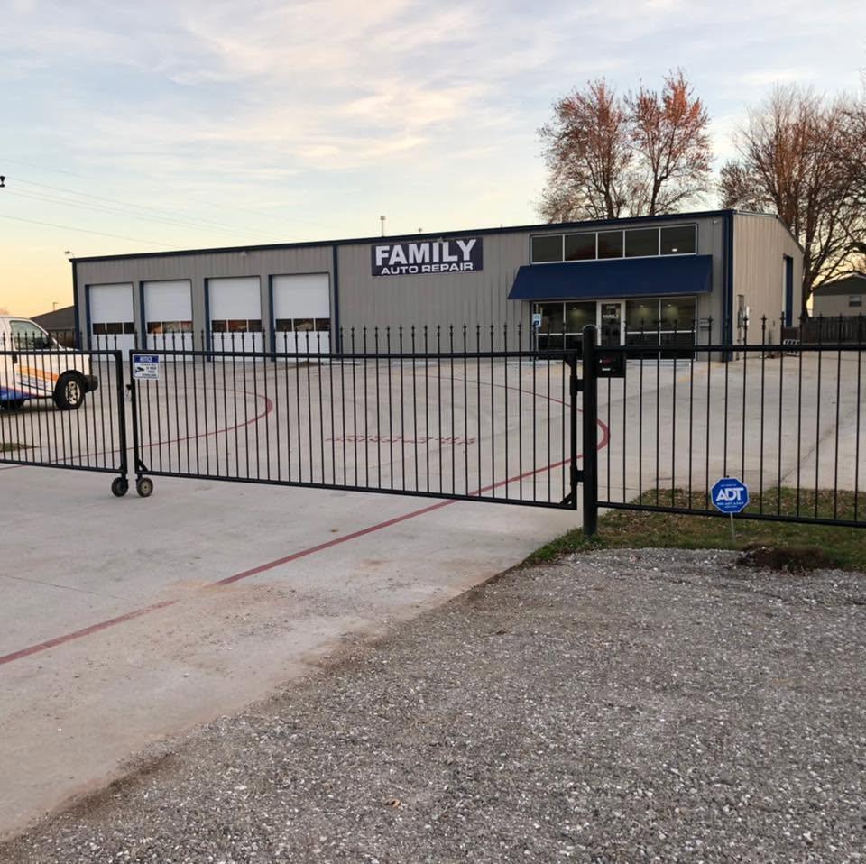 The Family Auto Repair building behind its gate, four bay doors along the front